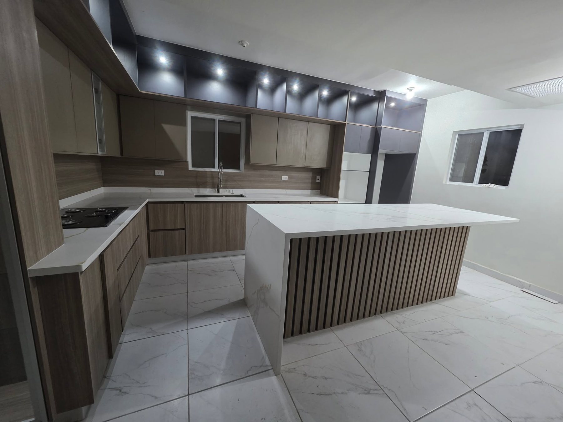 Cocina integral a la medida con isla de cuarzo, fabricada por HV Carpintería